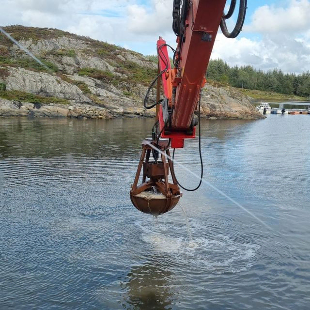 Gravemaskinarm over sjø