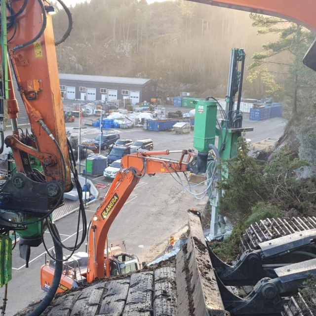 Gravemaskin i arbeid ved sjø