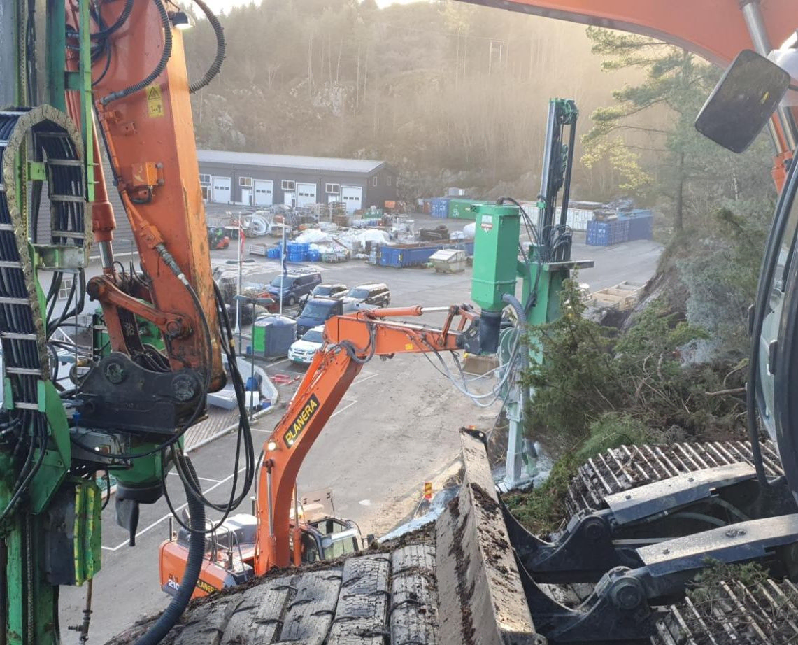 Gravemaskin i arbeid ved sjø