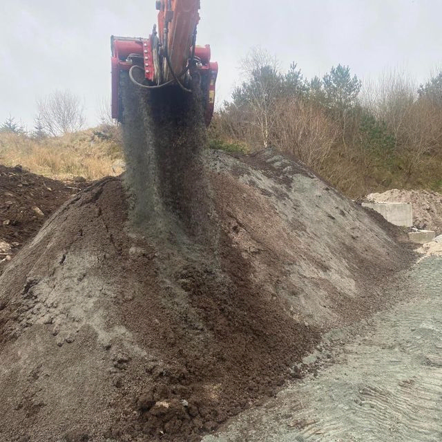 Gravemaskin heller grus i haug