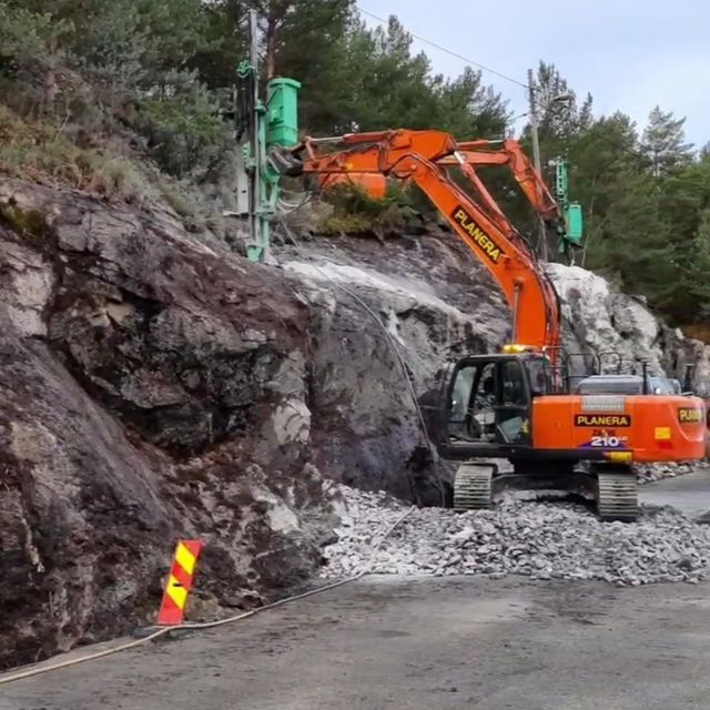 Gravemaskin i arbeid ved vei