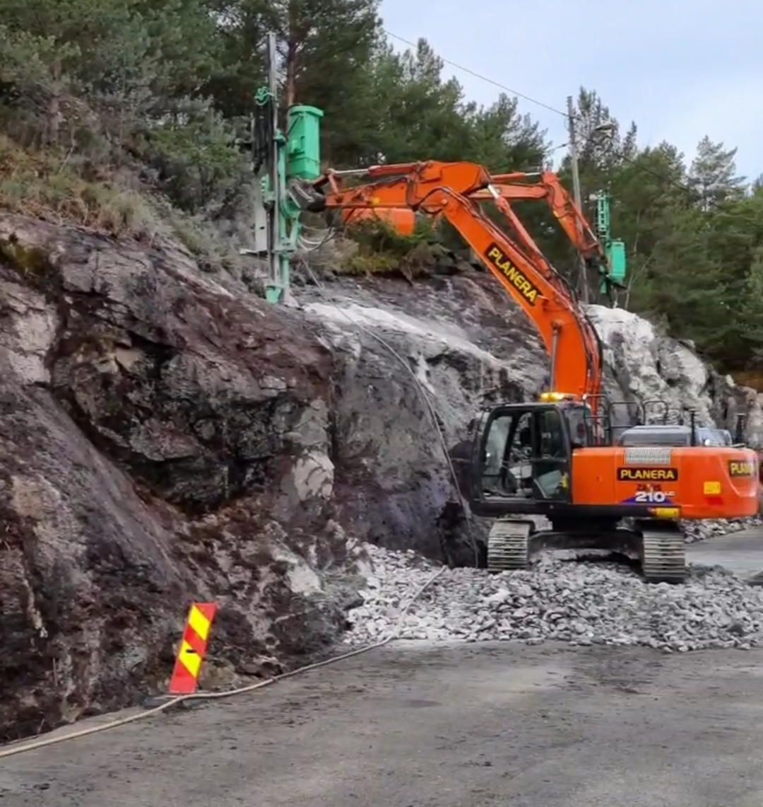 Gravemaskin i arbeid ved vei